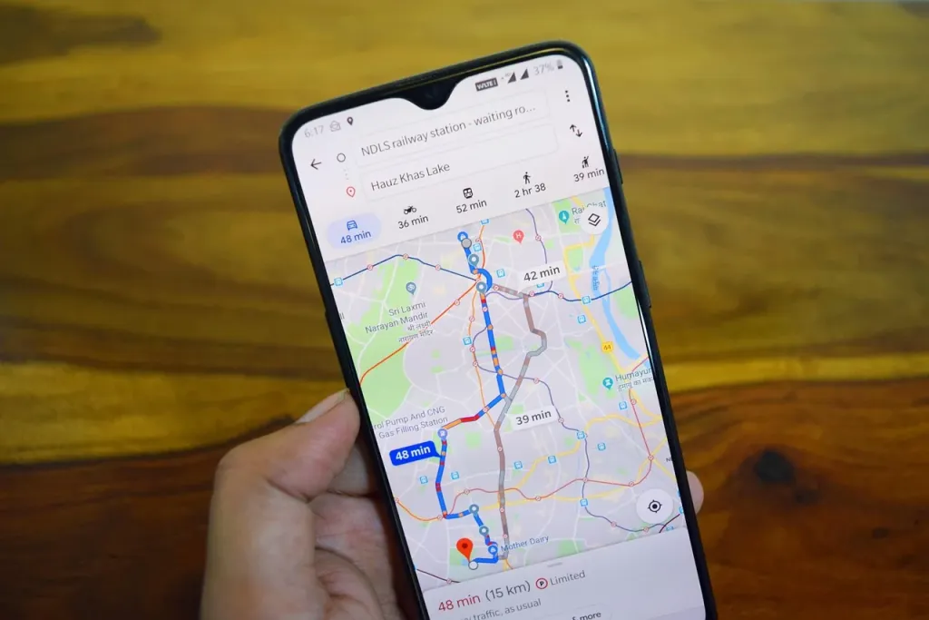 Ekran smartfona z wyświetloną interaktywną mapą i ikoną lokalizacji w przytulnym domowym biurze.